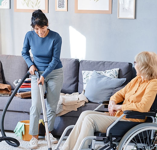 Woman helping to senior woman to clean the room